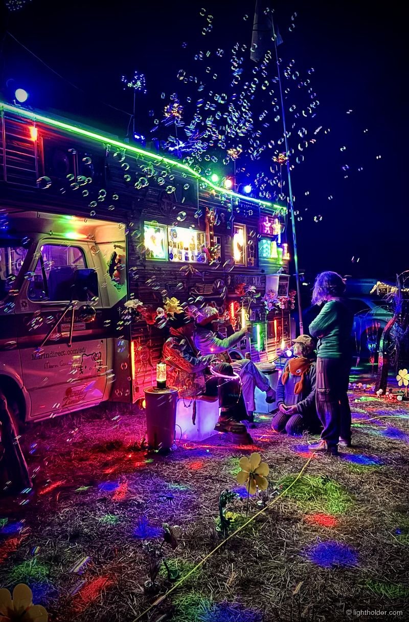 A colorful light display and bubble machine entertains festival-goers