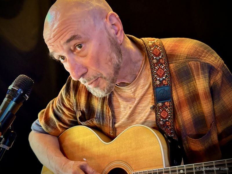Mich Shaffer leans over his guitar